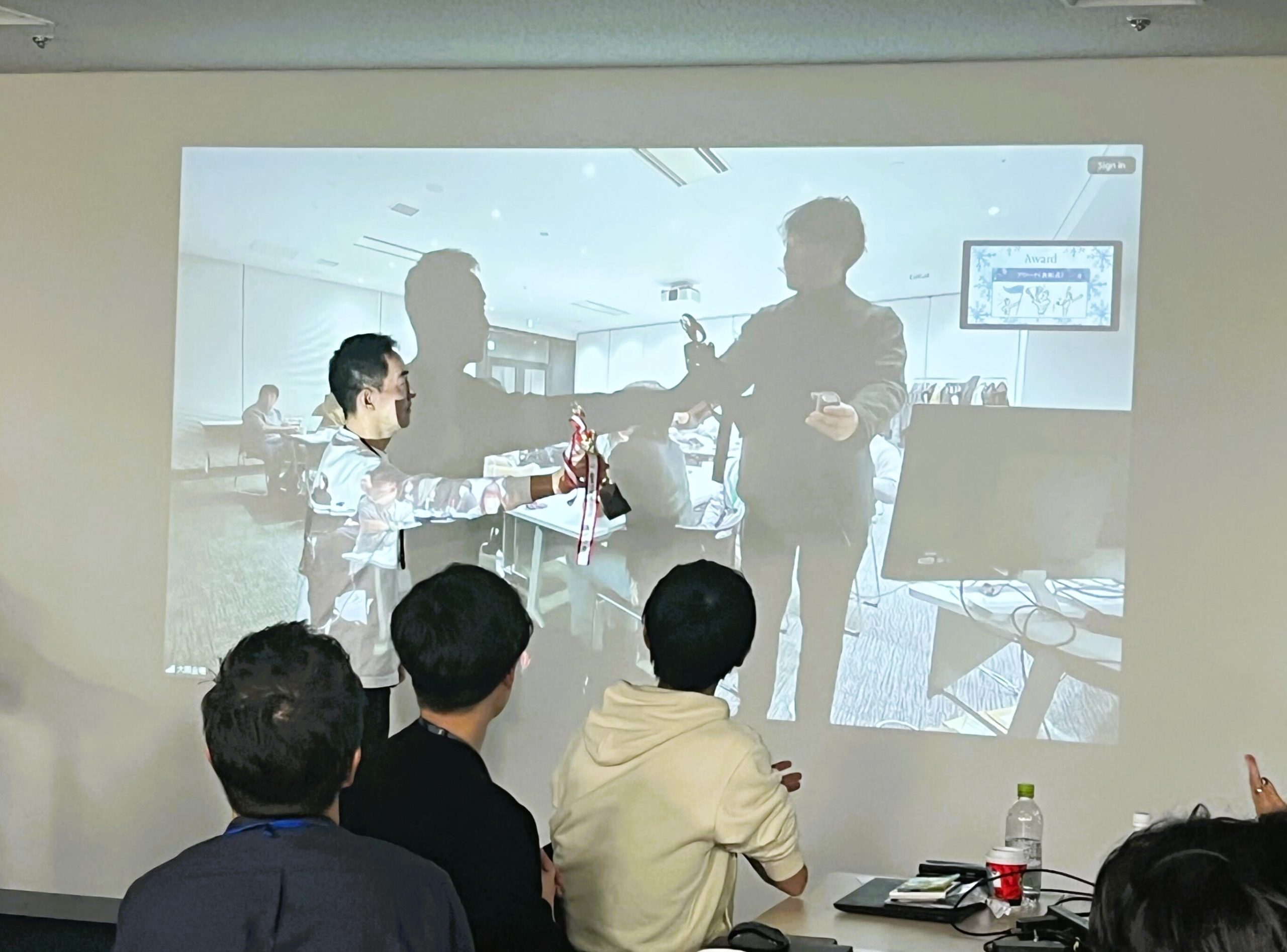 東京から大阪へ画面越しでトロフィーを贈呈する網野CEO